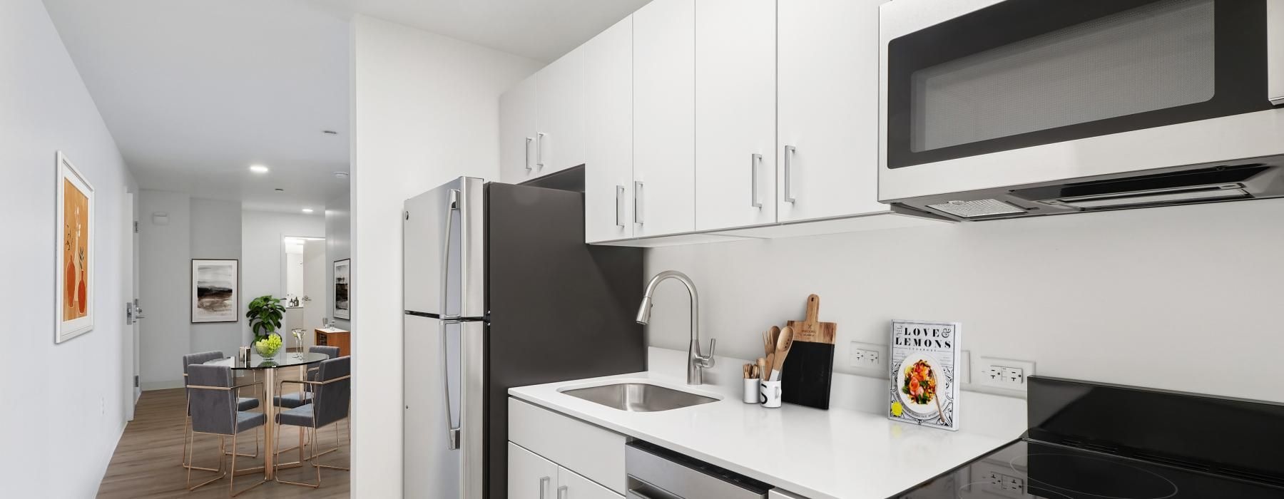A kitchen with white cabinets and stainless steel appliances at The Katherine apartments in Philadelphia